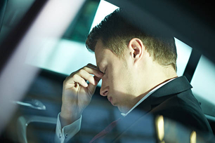 Exhausted businessman sitting in car