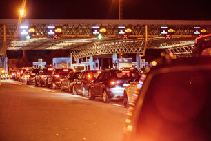Queued cars waiting at point of toll checkpoint during rush hour at night