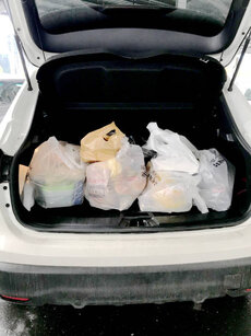 Istanbul/Turkey - November 18 2020: Plastic shopping bags with food in the trunk of a car. People buy food in large quantities due to the coronavirus. COVID-19.