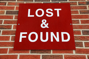 Red lost and found sign on brick wall