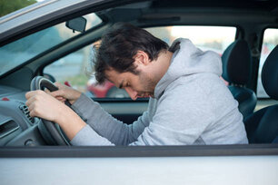 Man falling asleep in car after long hour drive