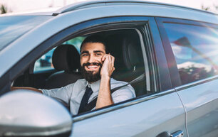 Handsome businessman talking on the phone while waiting in the car