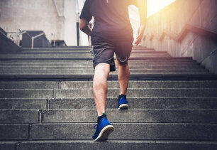 Close up of young man running up the stairs with running clothes