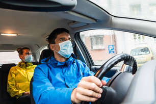 Taxi Driver and his Customer with Protective Face mask inside a Car