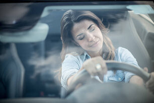 Tired woman driving a car and falling asleep