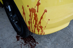 focus on the red blood splatter on the rear bumper of the car. concept of murder or traffic accident such as collision